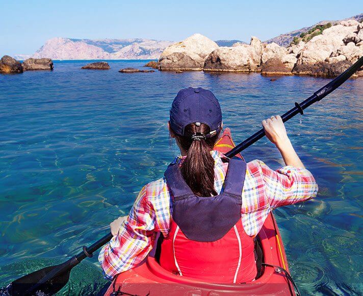 a girl kayaking in clear blue water