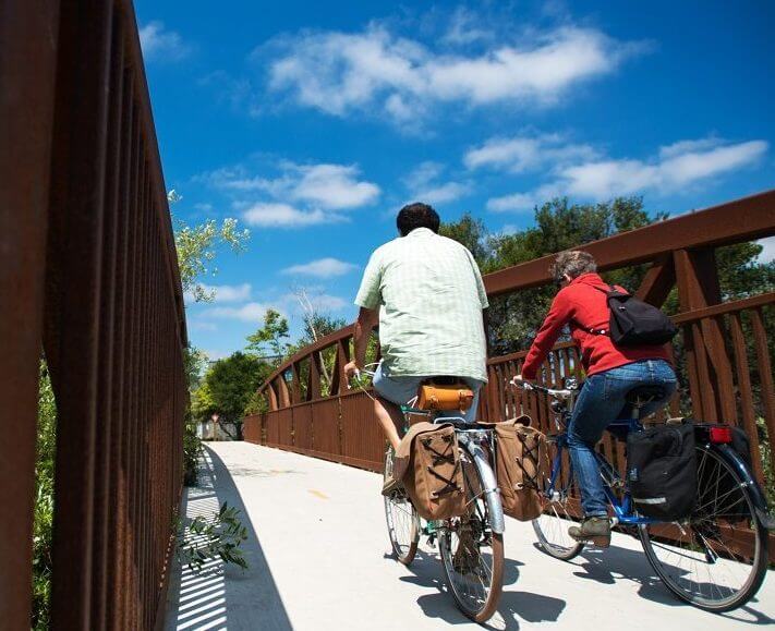 Featured Image 711 x 579 couple Riding bikes on Bridge