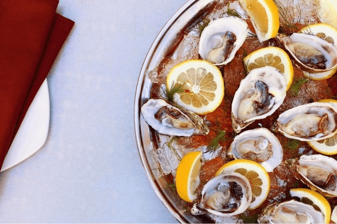 Oysters on ice with lemon wheels from above.